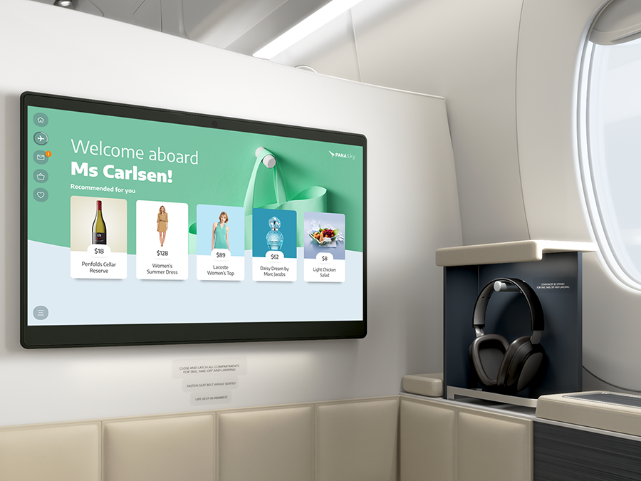 Airplane's first-class cabin with a digital screen displaying a welcome message and product recommendations